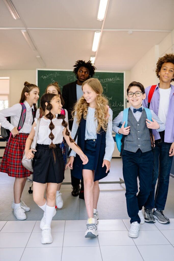 Diverse group of schoolchildren walking in a classroom with a teacher.