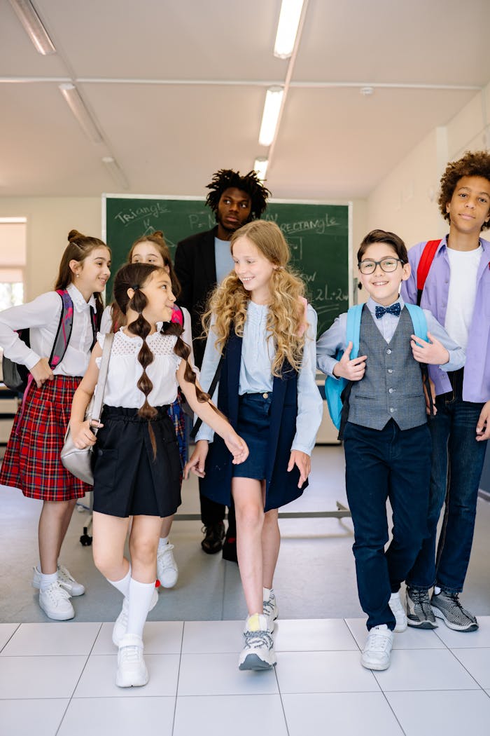 Diverse group of schoolchildren walking in a classroom with a teacher.